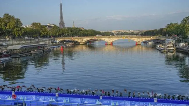 Atlet triatlon melompat ke Sungai Seine dari jembatan saat ajang uji coba triatlon putri untuk Olimpiade Paris 2024, 17 Agustus 2023. (Sumber: Michel Euler/Associated Press)