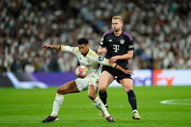 Duel Jude Bellingham dan Matthijs De Ligt dalam laga Real Madrid dan Bayern Munchen di Liga Champions 2023/2024, Kamis (9/5/2024) dini hari WIB. (c) AP Photo/Jose Breton