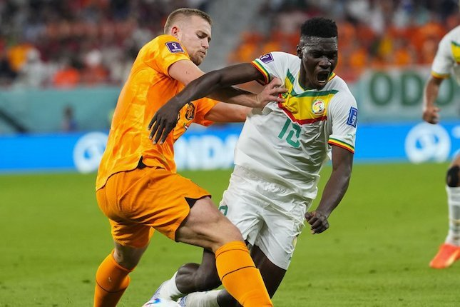 Matthijs De Ligt (kiri) berduel dengan Ismaila Sarr (kanan) di laga perdana grup A Piala Dunia 2022 antara Belanda vs Senegal, Senin (21/11/2022) (c) AP Photo/Petr David Josek